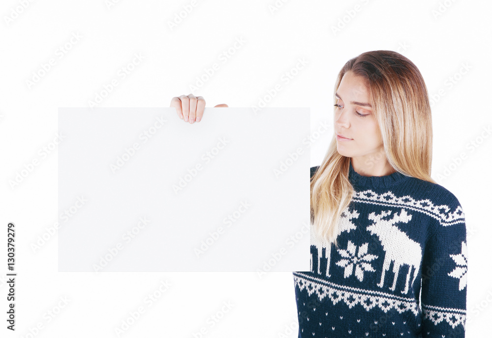 Donna tiene cartello bianco in mano pubblicità con maglione invernale