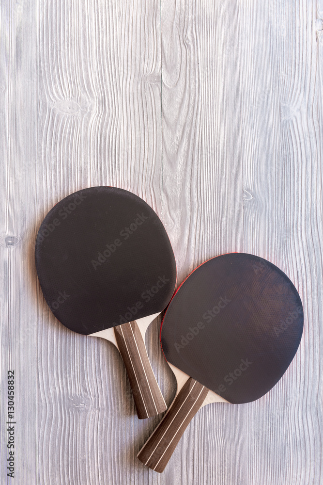 black racket for ping pong ball wooden background top view