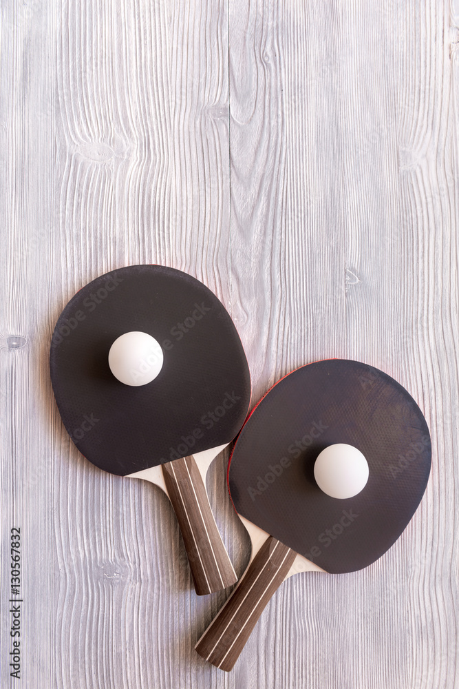 black racket for ping pong ball wooden background top view