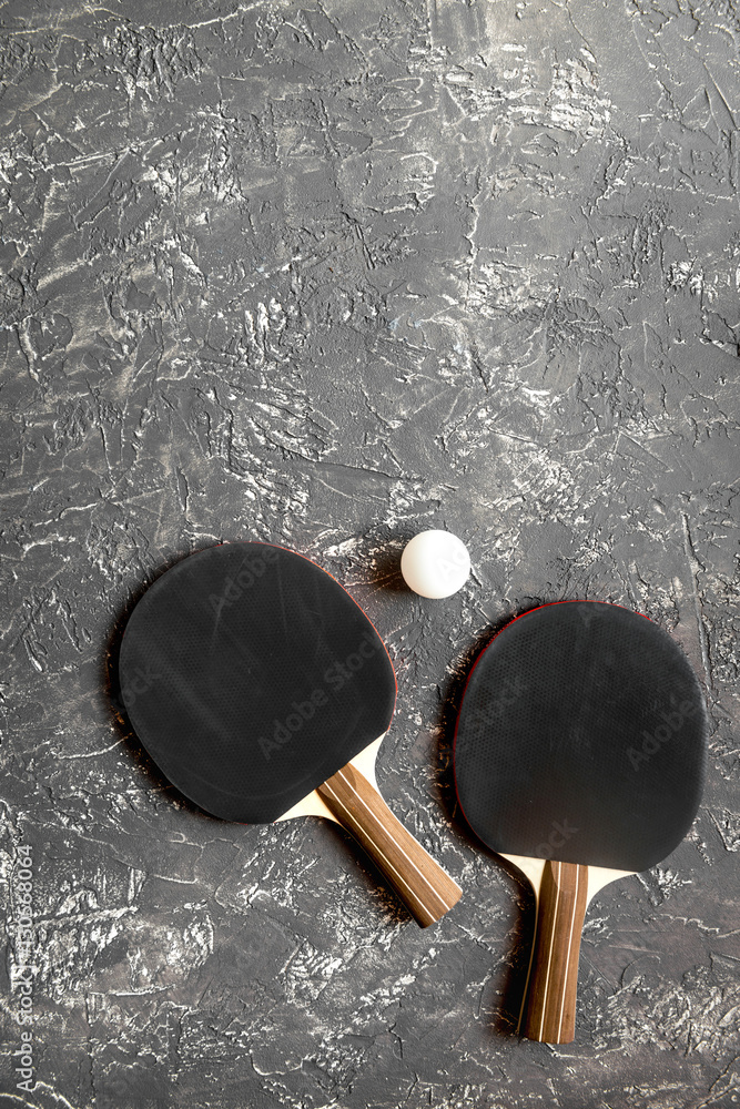 black racket for ping pong ball gray background top view