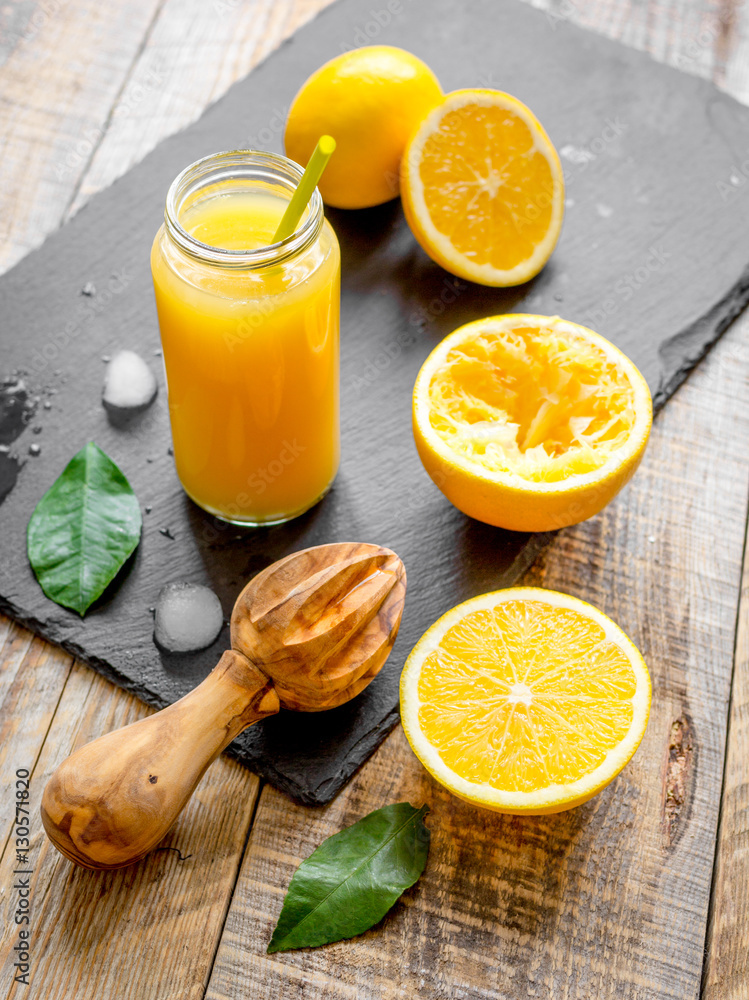 freshly squeezed orange juice in glass bottle on wooden background