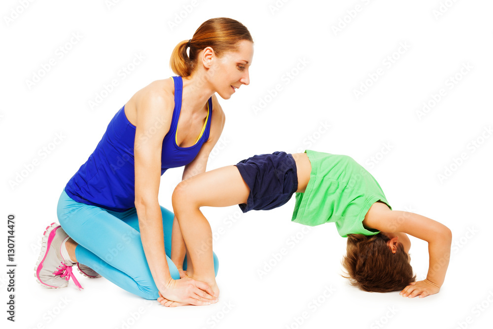 Female trainer teaching kid boy making a crab pose