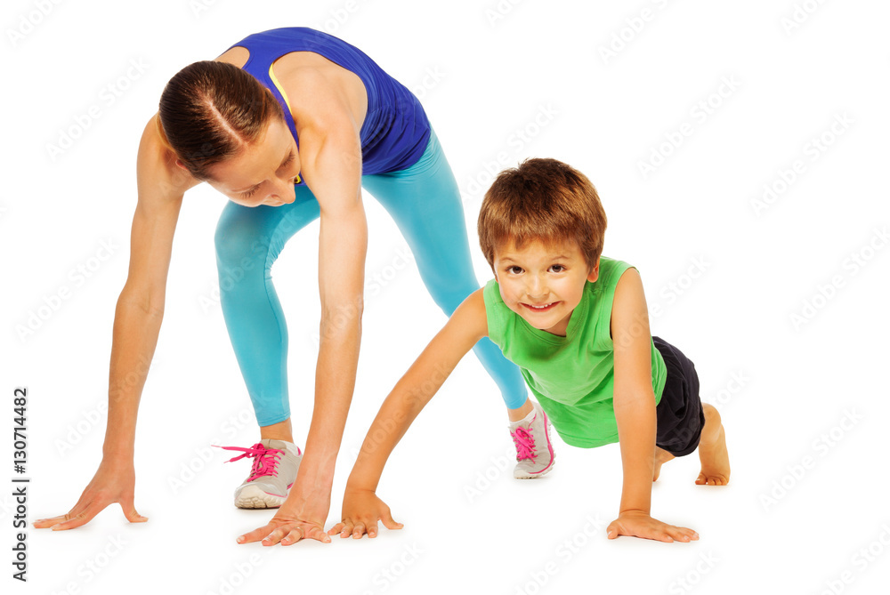 Sporty mother doing pushing ups with her kid son