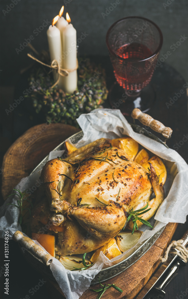 Christmas holiday table set with roasted whole chicken stuffed with oranges, bulgur and rosemary, de