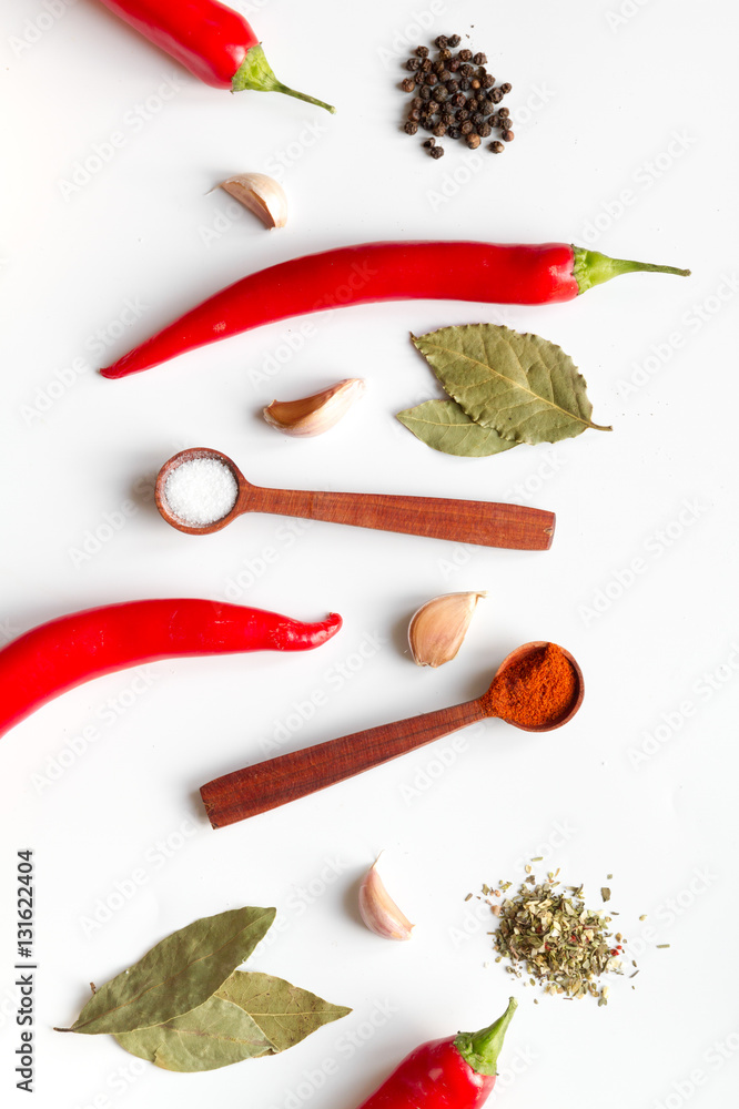 spices in wooden spoons on white background top view