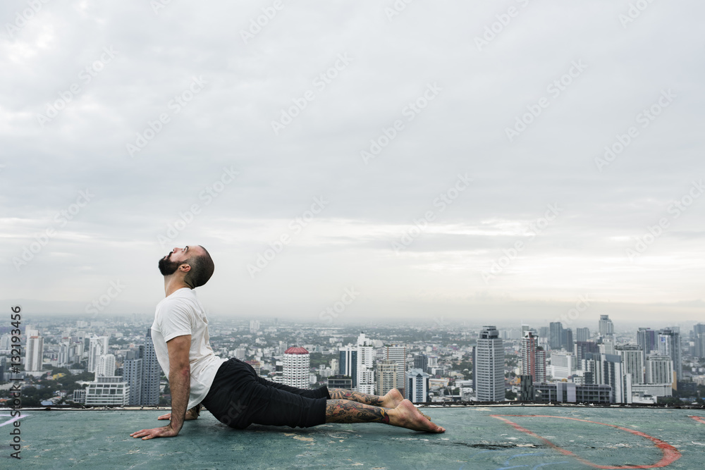 男子练习瑜伽屋顶概念