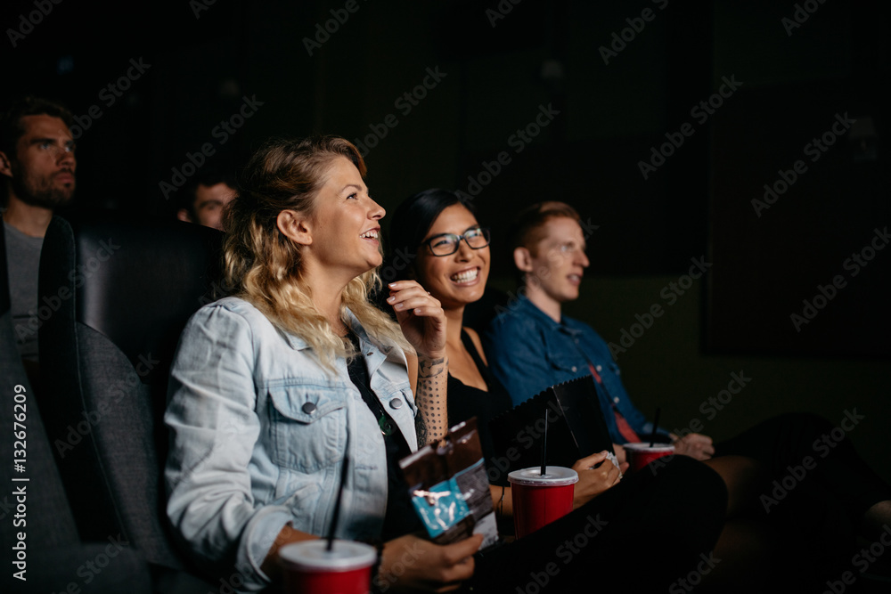 Happy young people watching movie in cinema
