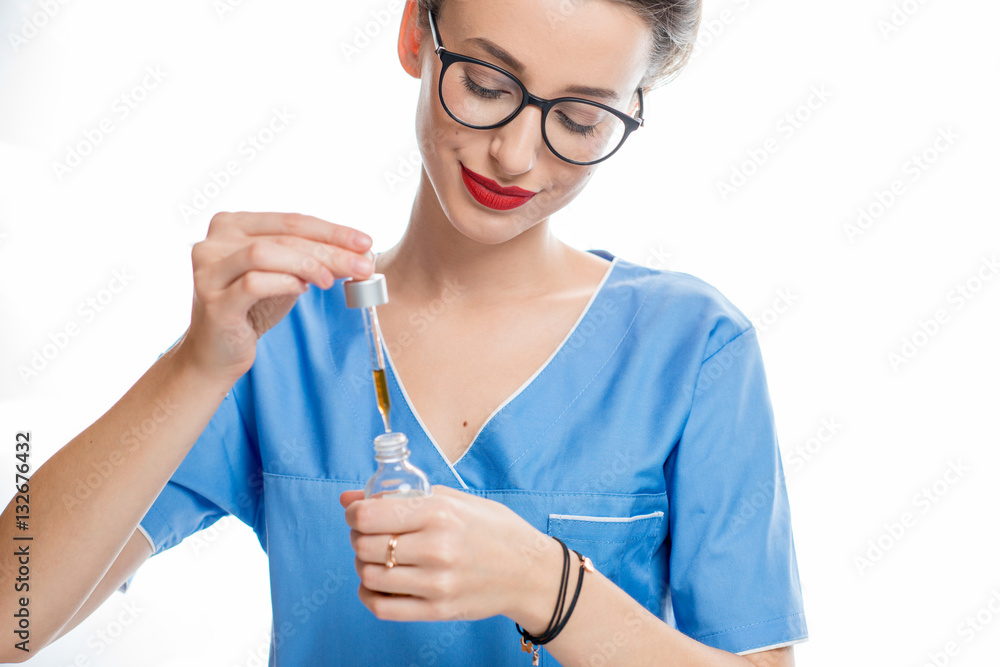 Young female cosmetologist or doctor with medical dropper on the white background