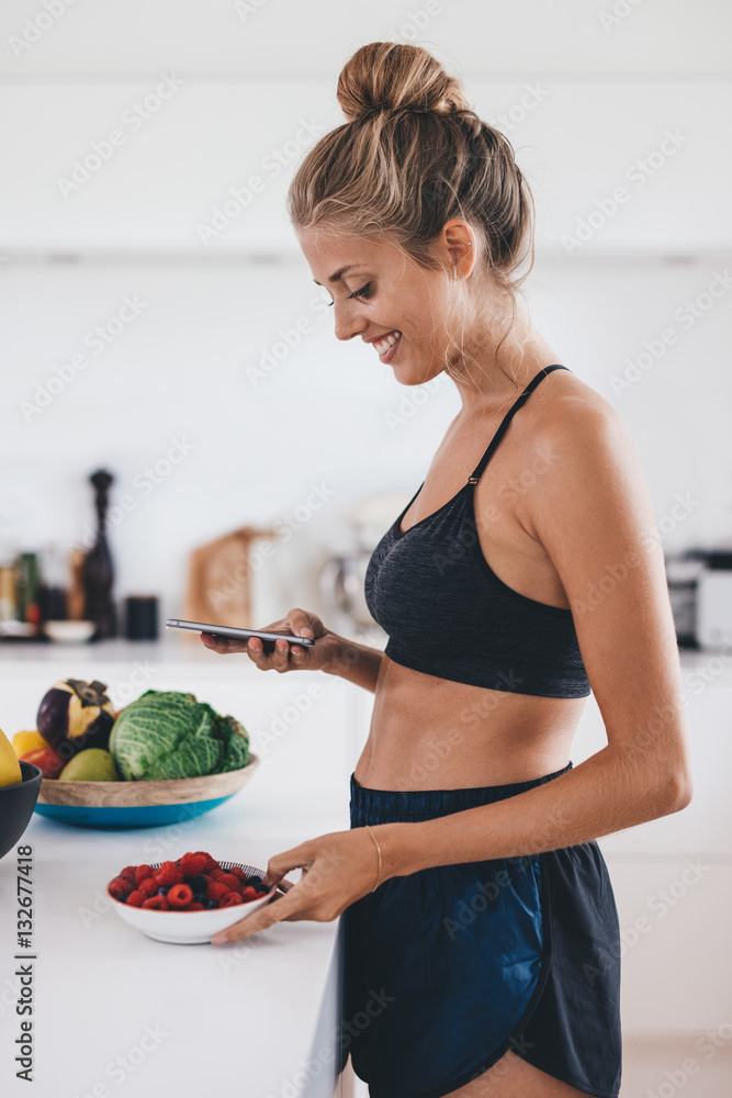 Beautiful woman in kitchen using mobile phone