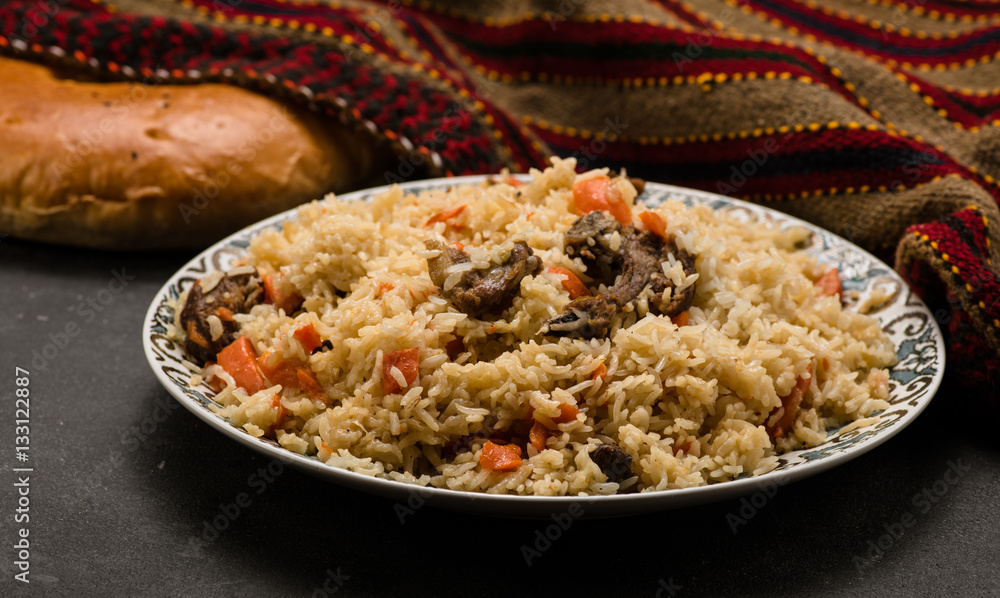 Pilaf on plate with oriental ornament and Traditional Asian breads - churek. Plov.
