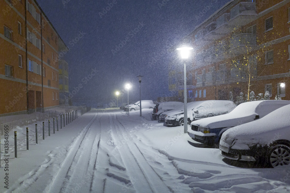 Snowy street with cars after winter snowfall in Poland