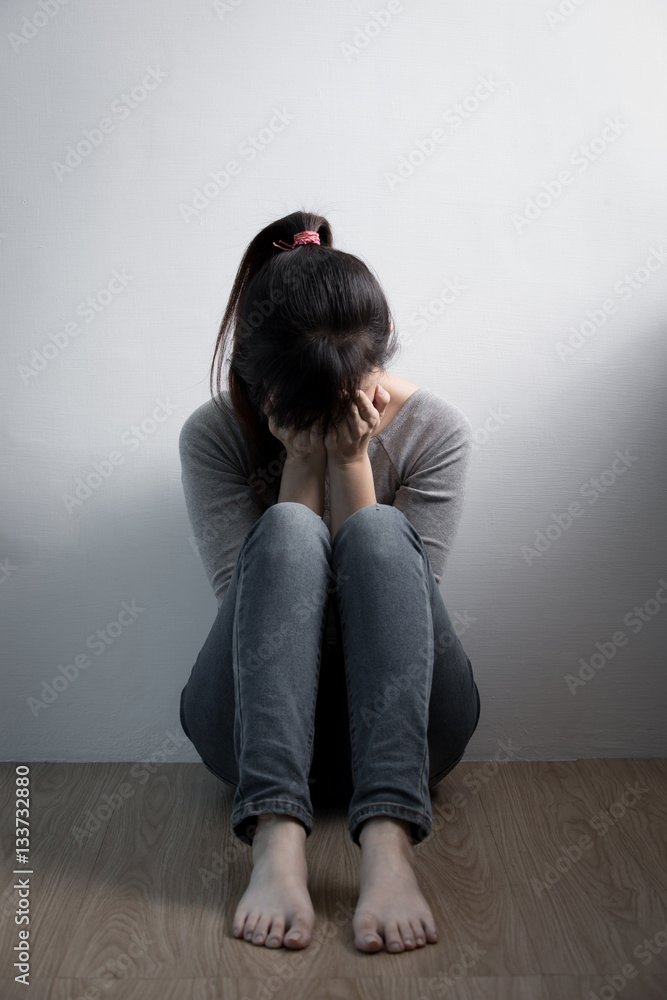 抑郁的女人坐在地板上