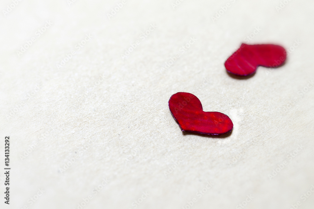 Red petal in heart shape on brown paper background