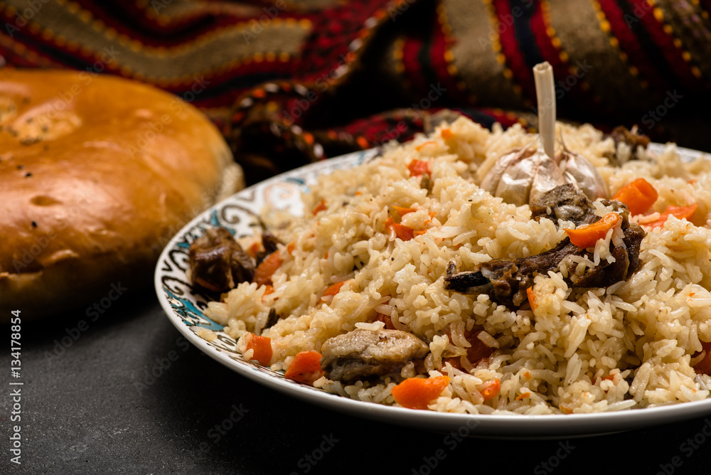 Pilaf on plate with oriental ornament and Traditional Asian breads - churek. Plov.