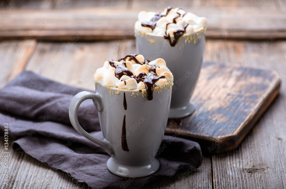 Smores drink. Two mugs of hot chocolate with marshmallows on a wooden table. Cocoa.