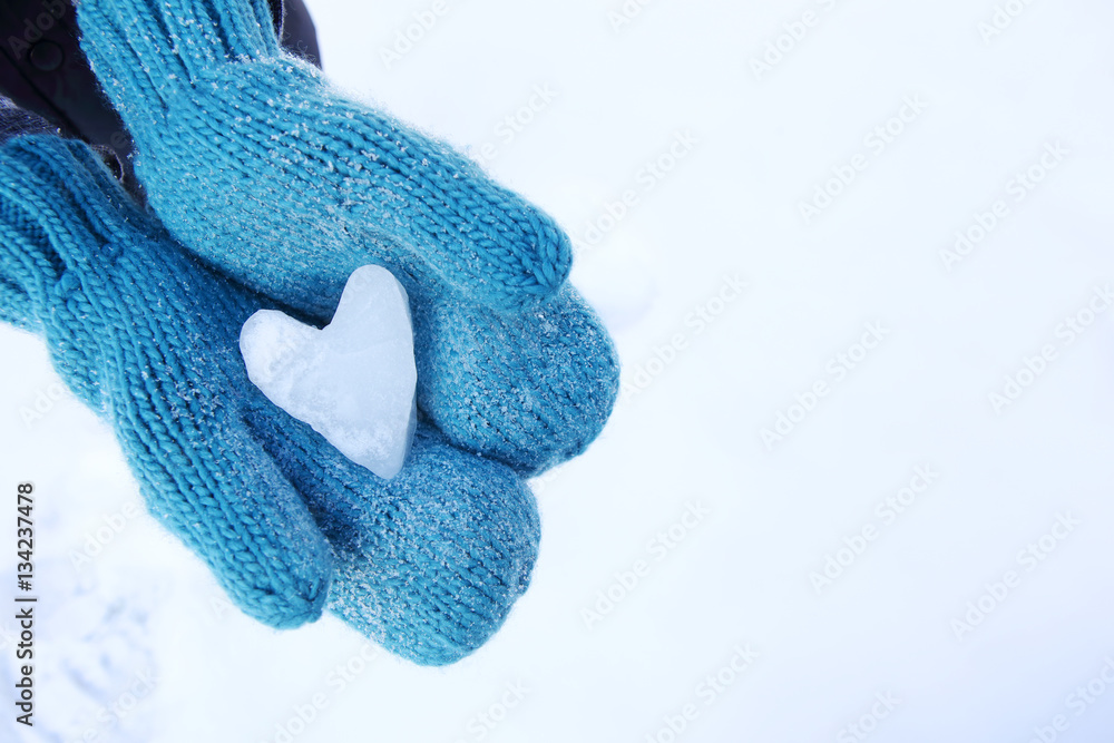 Mittens holding a snow heart shape