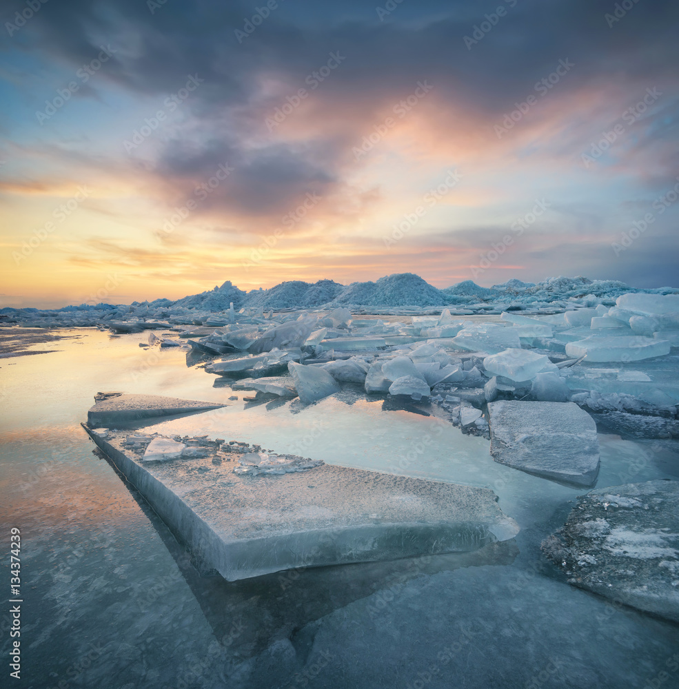 日落时的冰冻海洋。冬季美丽的自然海景