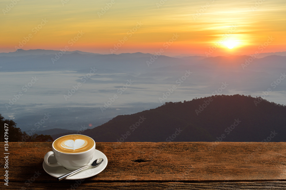 日出时一杯山背景的早晨咖啡拿铁