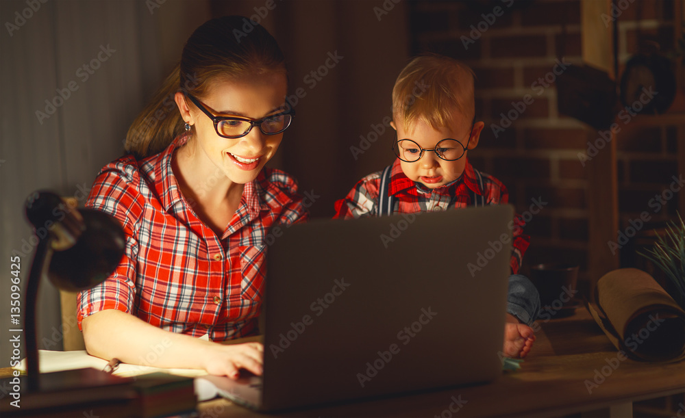 女妈妈在家里用电脑抱着孩子工作