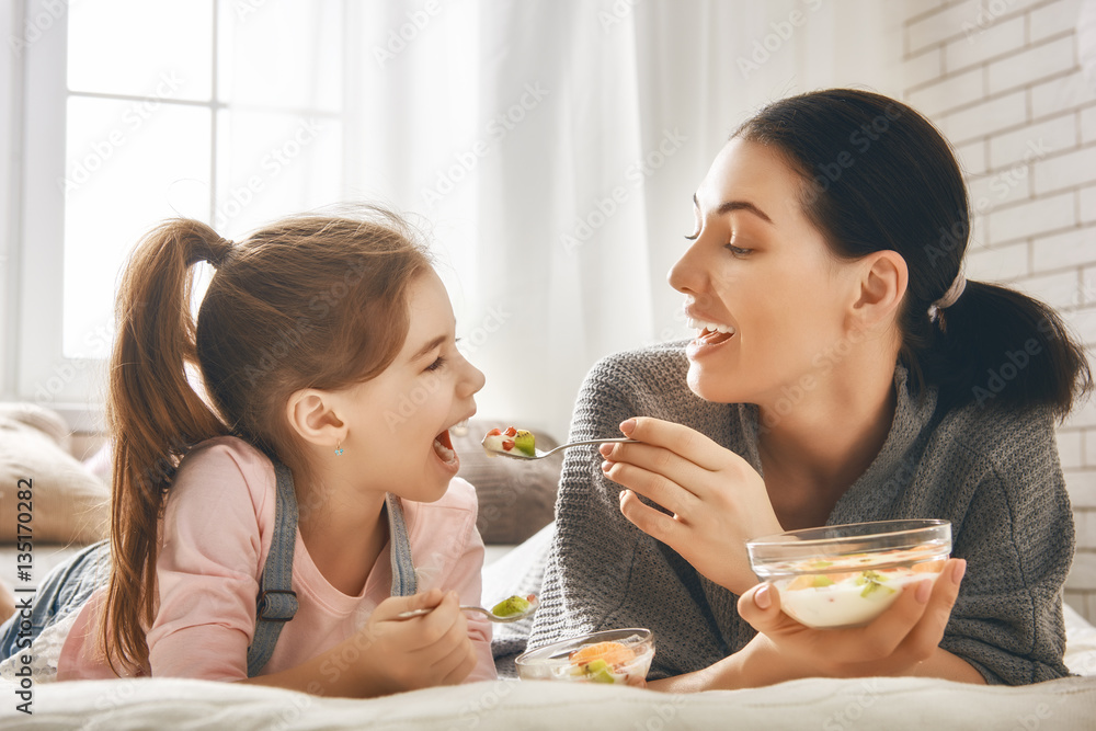 Mother and daughter eating salad