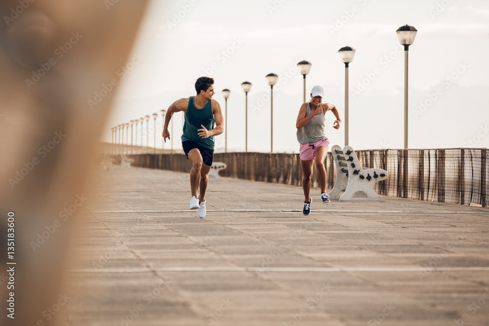 健身情侣在海滨大道上疾跑