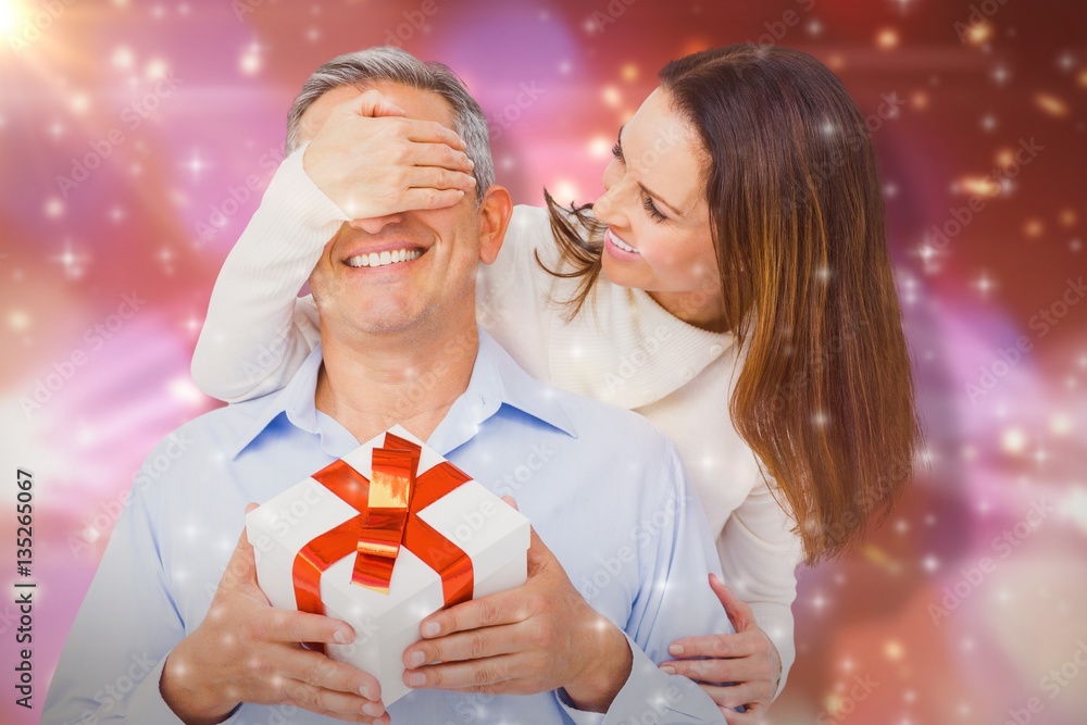 Composite image of wife covering eyes of husband 