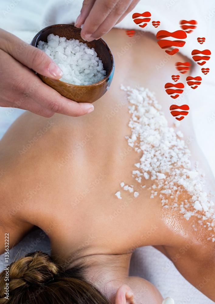 Woman getting sea salt massage on back