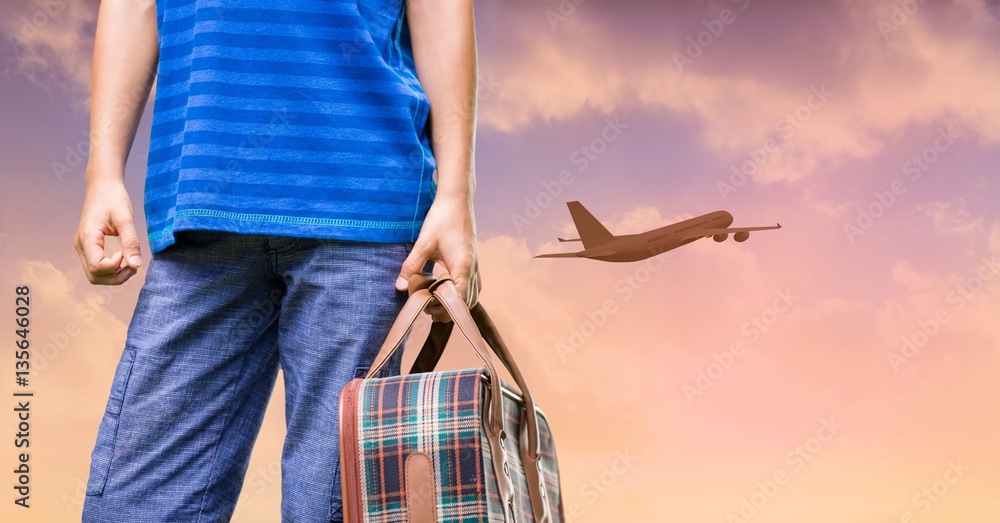 Man holding suitcase and plane flying in sunset sky