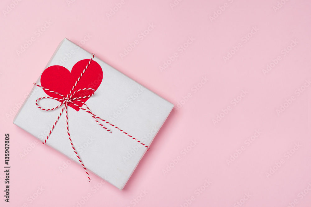 Valentines day composition: gift box with bow and hearts on red