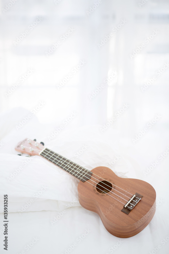 Classic Ukulele guitar on bed