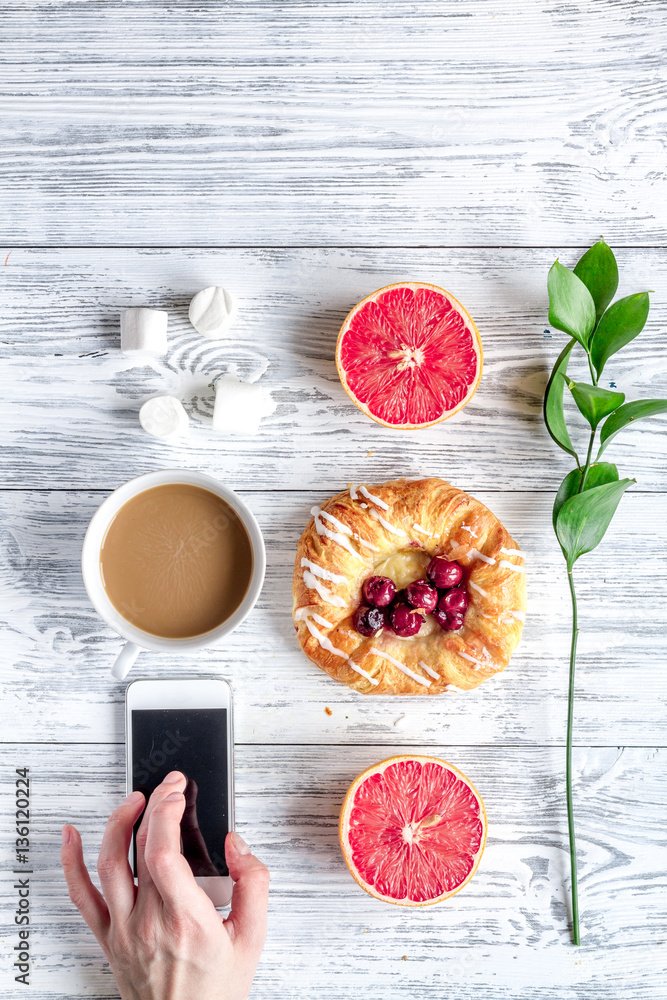 Breakfast concept with flowers on wooden background top view