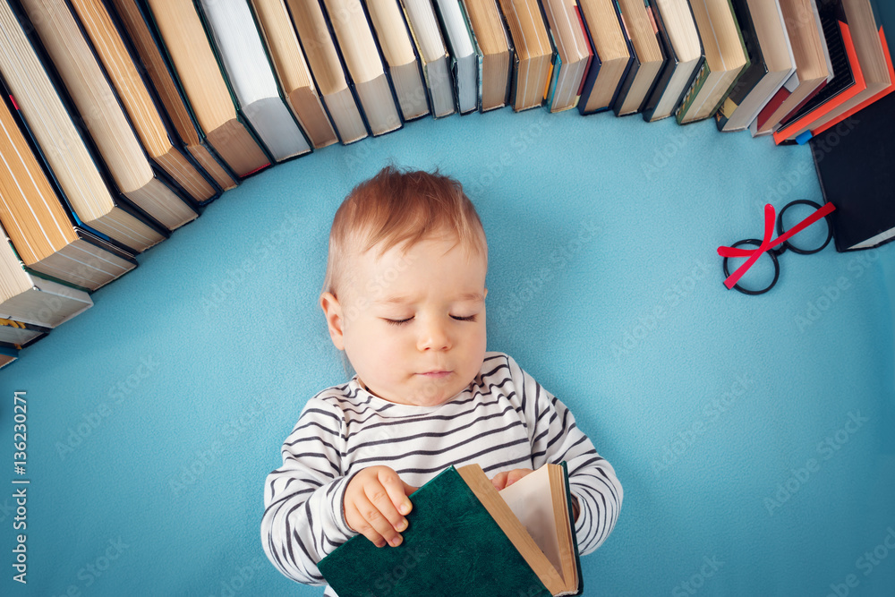 One year old baby with spectackles and books
