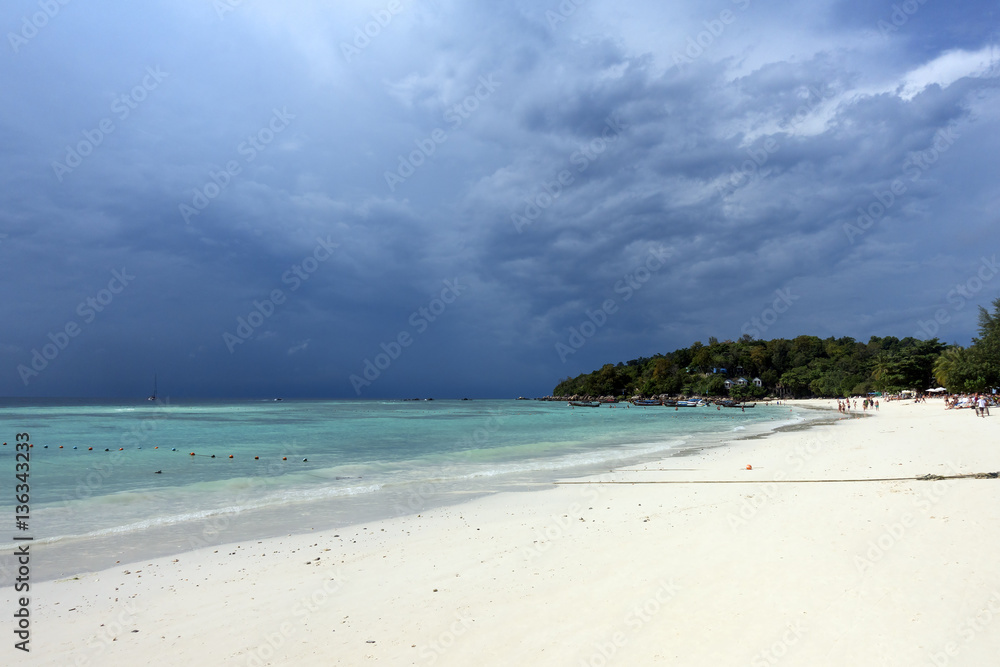 White sandy beach on stormy sky background