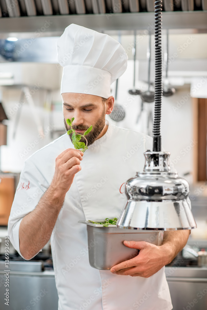 Handsome chef cook checking the freshness of green mint at the restaurant kitchen