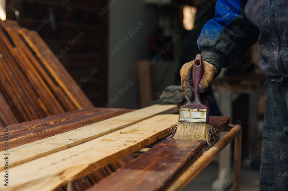 Varnishing a wooden plank using paintbrush