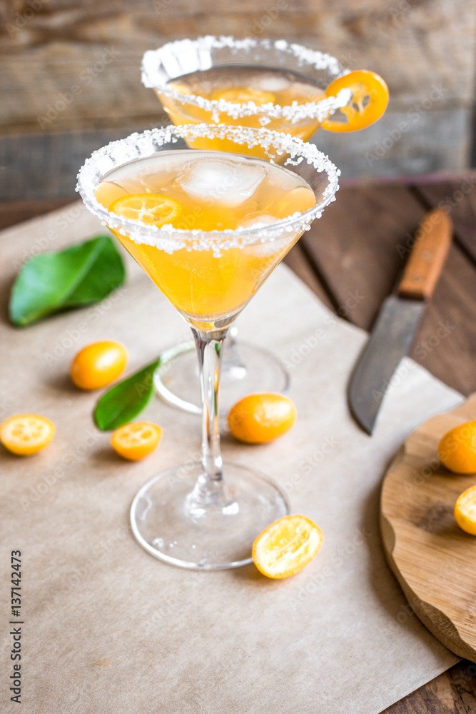 cocktail with kumquat on wooden background