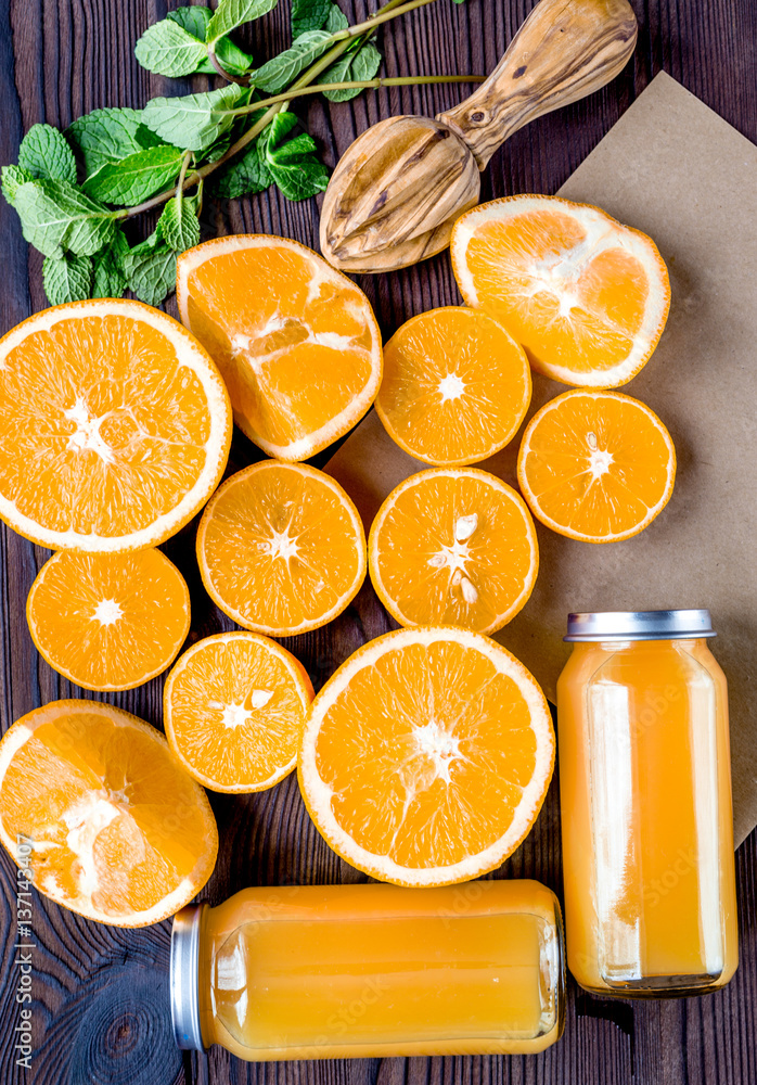 Orange juice in bottle with slices and mint on table top view
