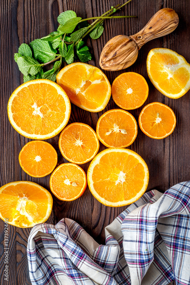 Fresh oranges in slices with mint leaves on kitchen top view