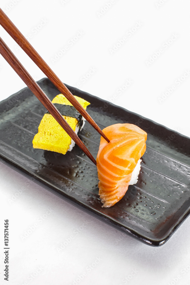 Japanese sushi raw seafood, vegetables and serving of cooked vinegared rice on white table backgroun