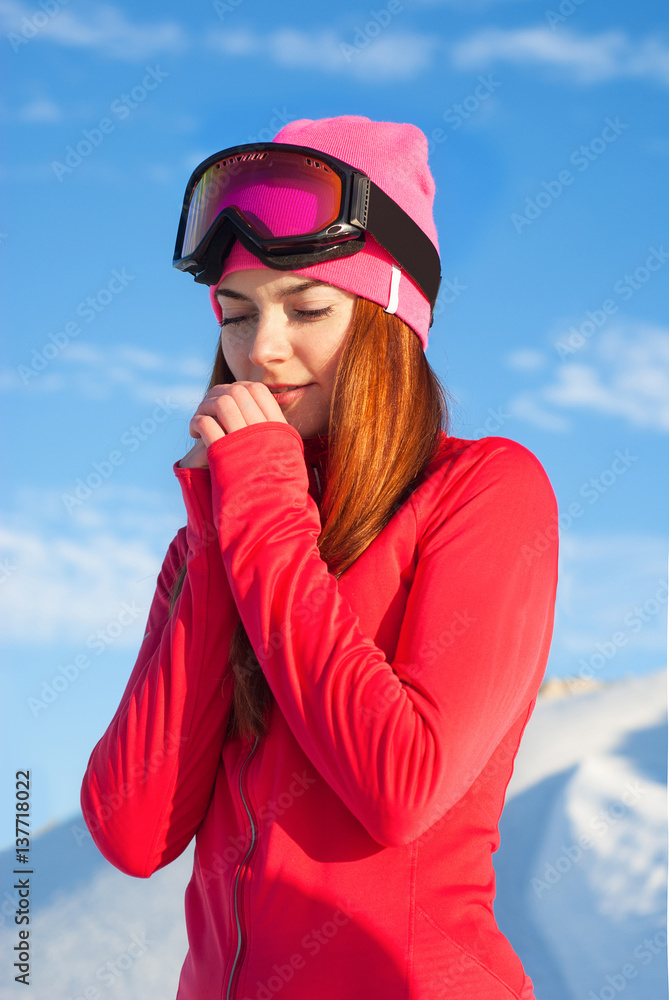 Cute girl standing on top of a snowy mountain