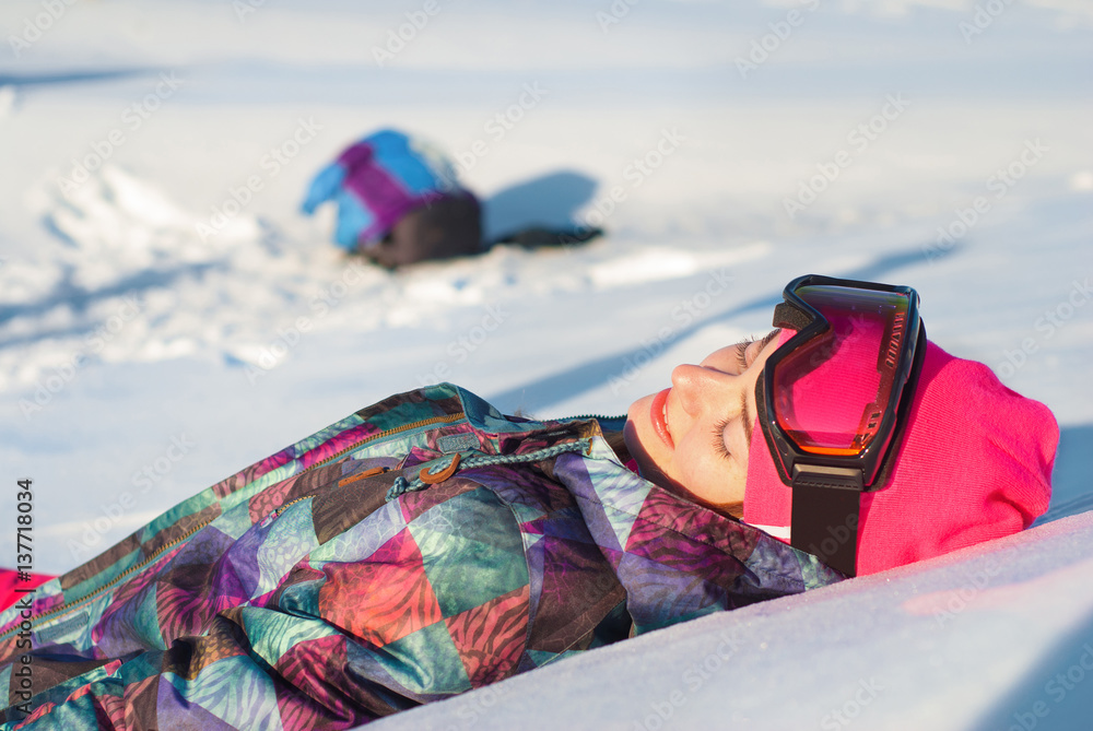 可爱的微笑女孩穿着滑雪服，在雪山上放松