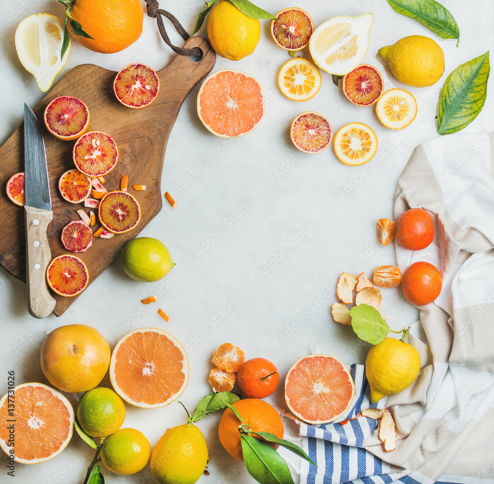 天然新鲜柑橘类水果片，放在灰色大理石桌子背景上的乡村木板上。