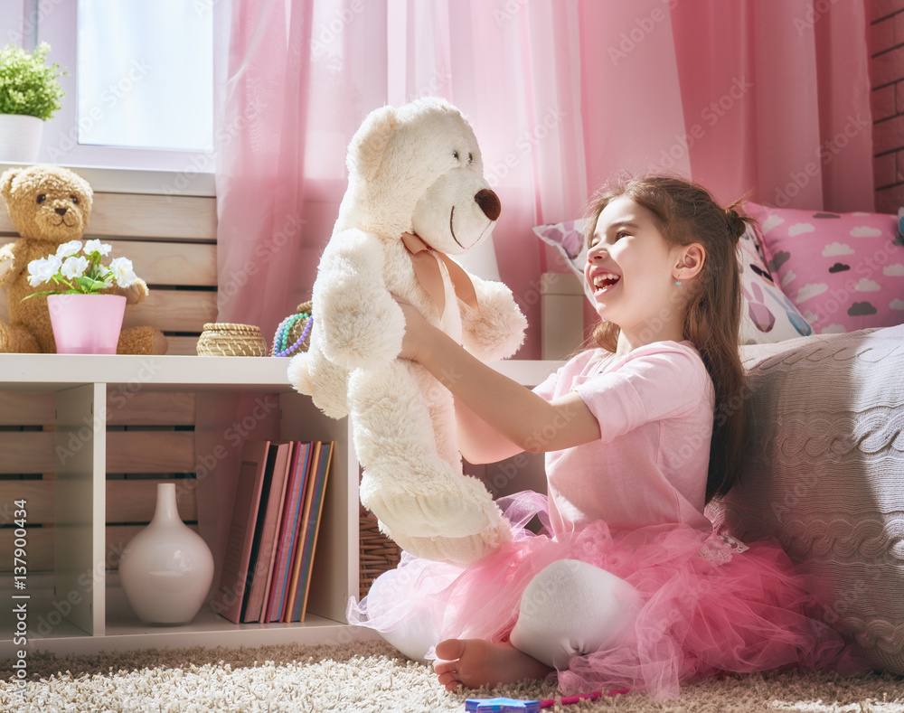 girl plays with teddy bear