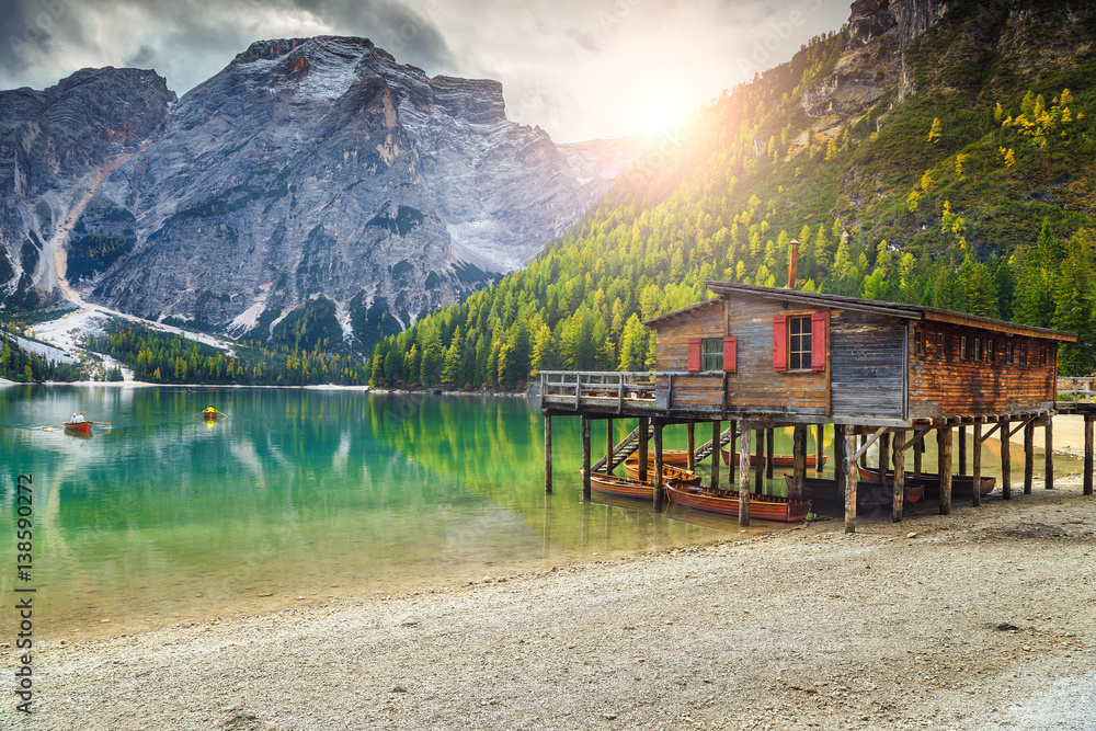 Wooden boathouse and boats on the alpine lake, Dolomites, Italy