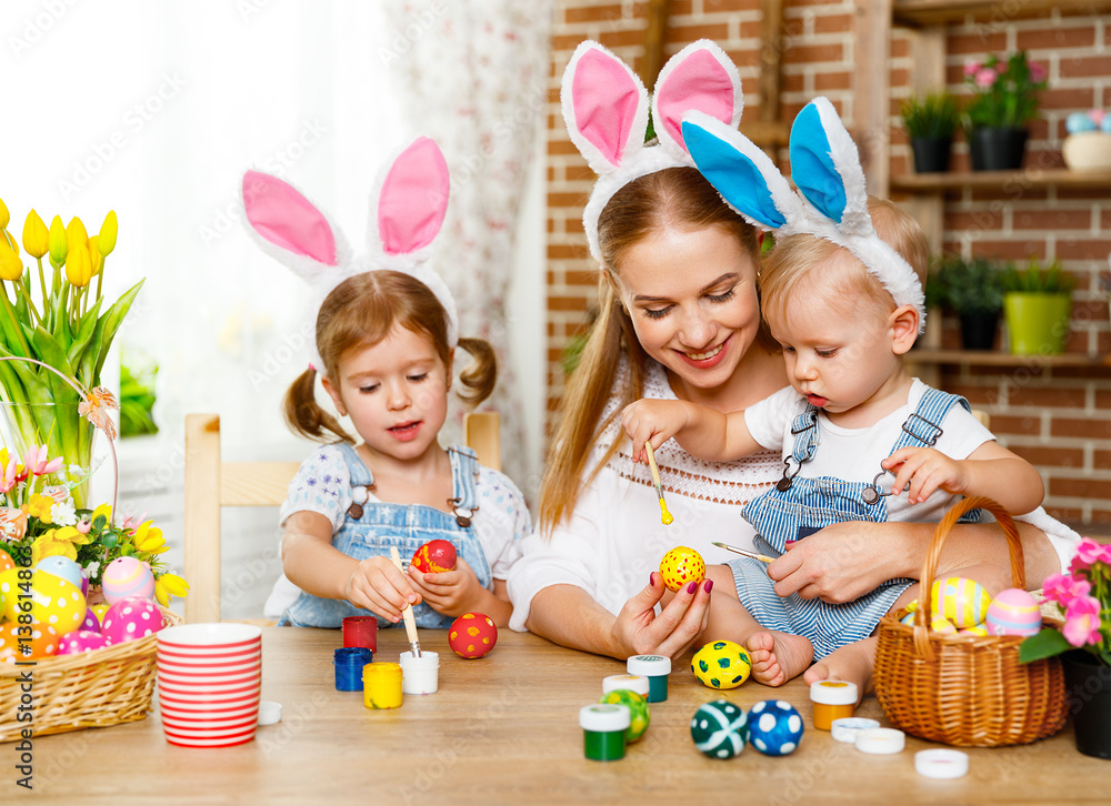 Happy easter! family mother and children paint eggs for holiday Easte