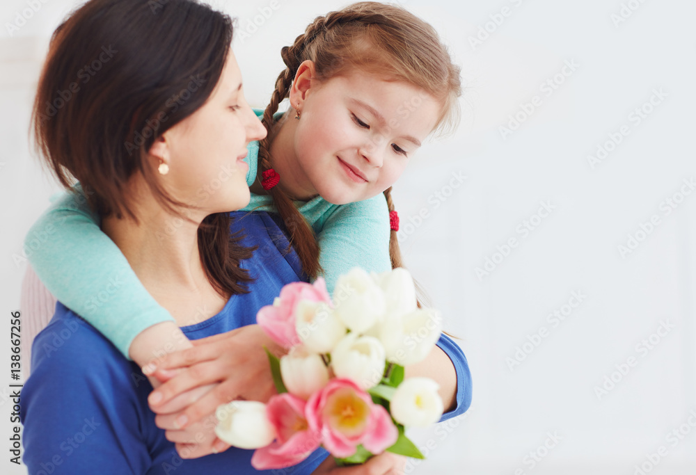 portrait of happy mother and daughter with spring flower bouquet