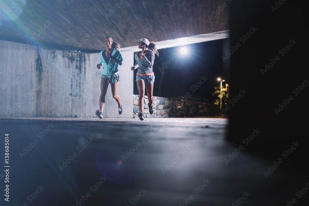 两名年轻女子在城市夜间慢跑