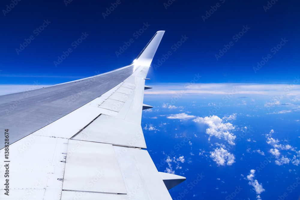 Aerial view of airplane wing over blue sky