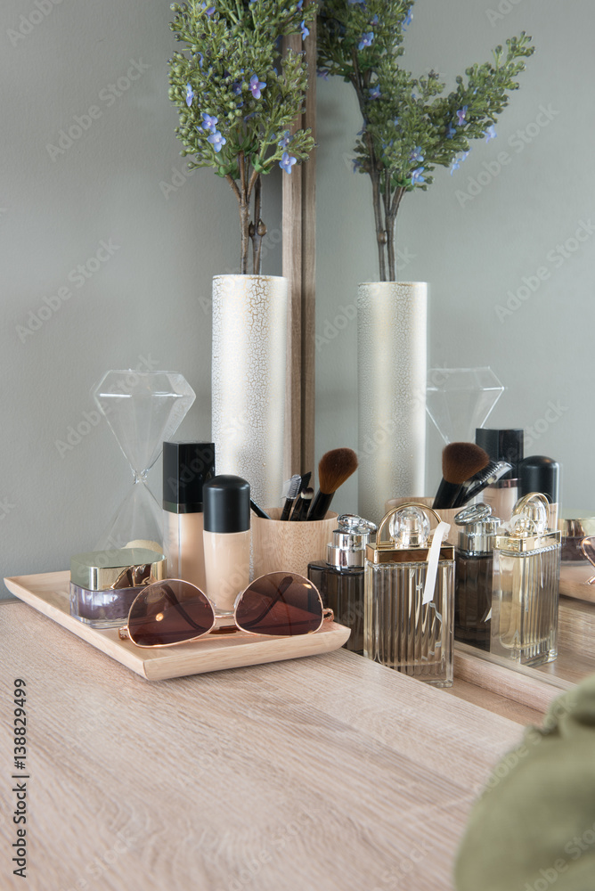 Beauty and make-up concept: table mirror, flowers, perfume, jewelry and makeup brushes on wooden tab