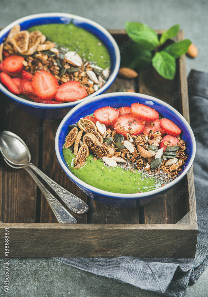 Healthy breakfast. Green smoothie bowls with strawberries, granola, chia and pumpkin seeds, dried fr